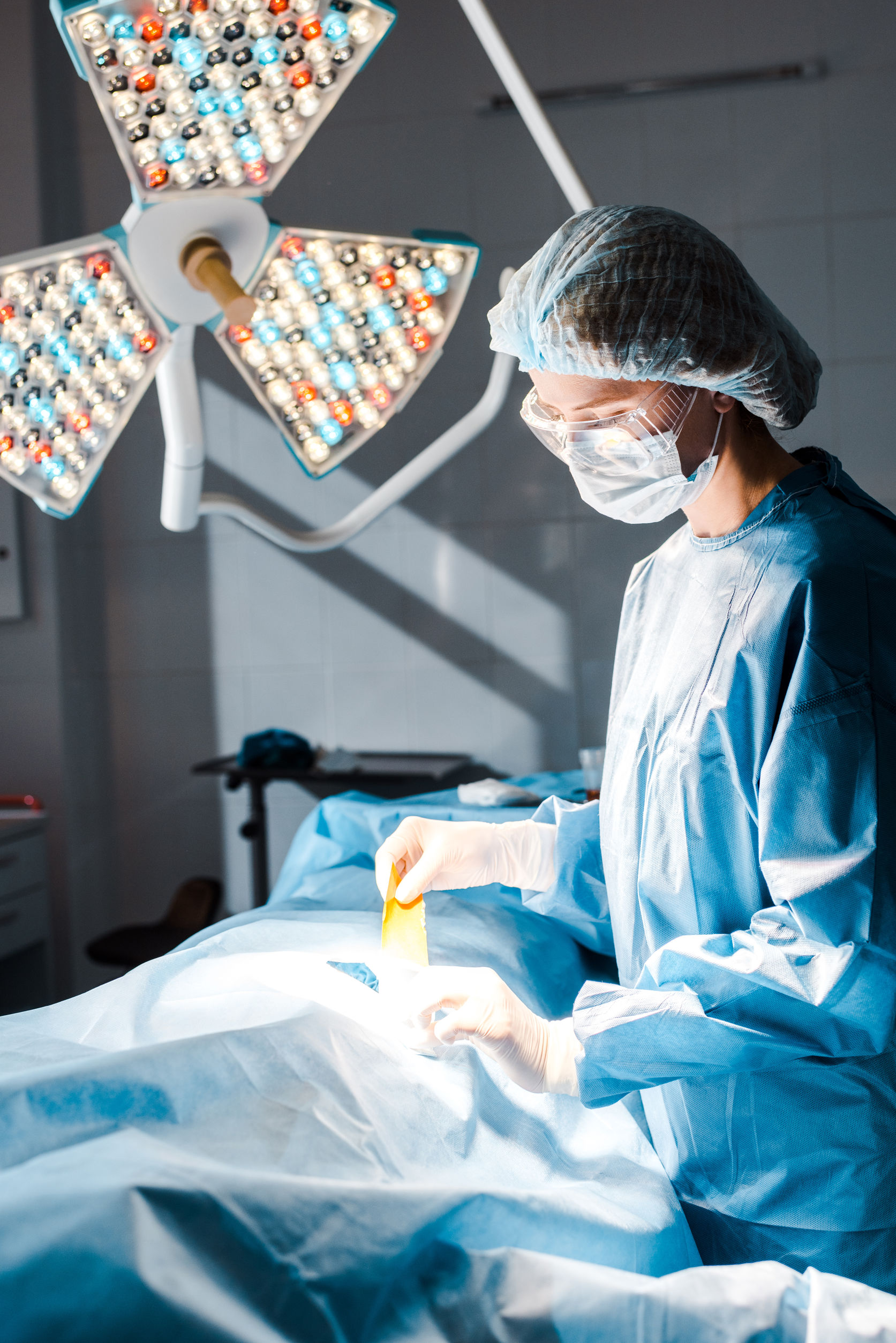 nurse in uniform and medical cap holding strip in operating room